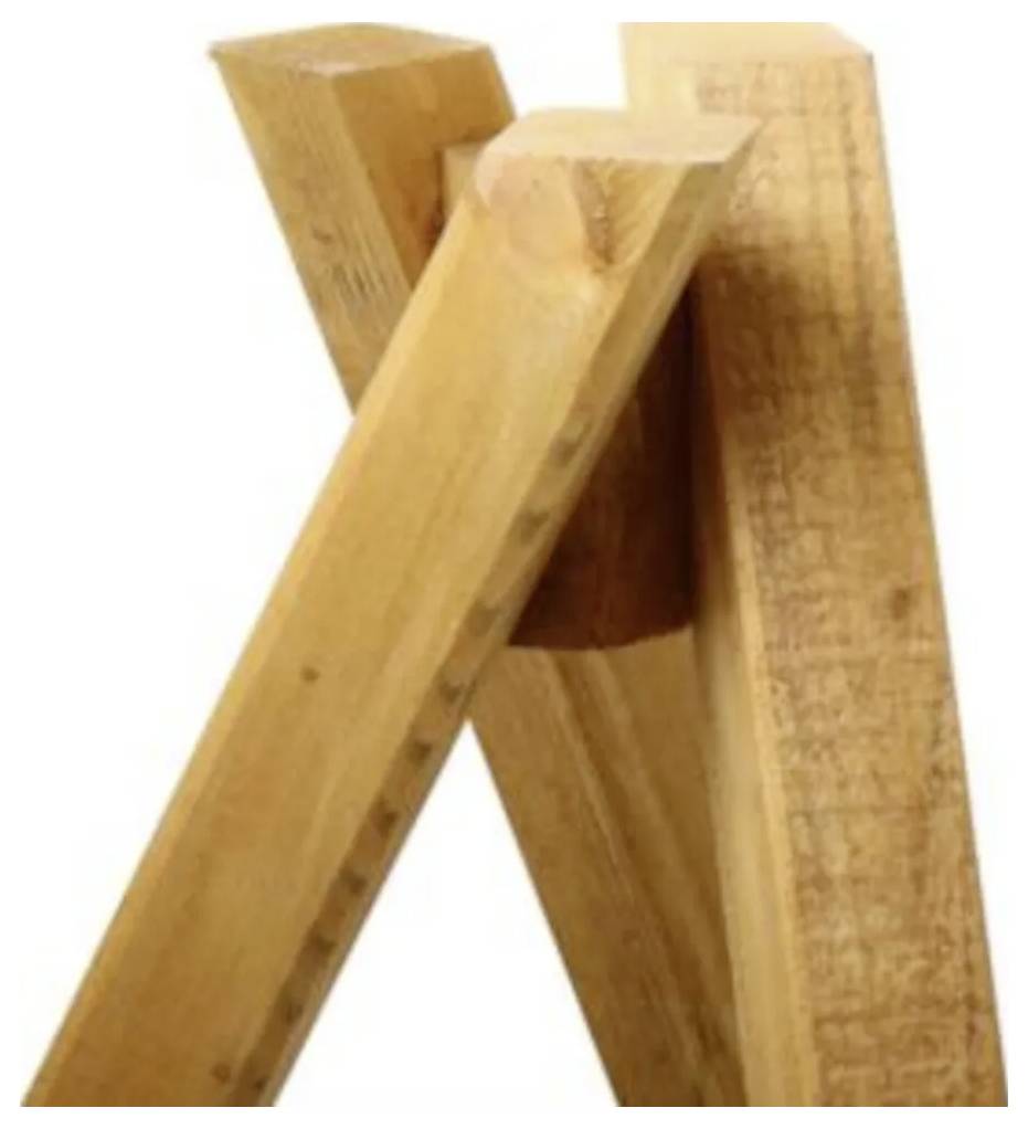 Drewniane deski są ustawione pionowo, przecinające się na czubku, tworząc prostą, rustykalną konstrukcję.