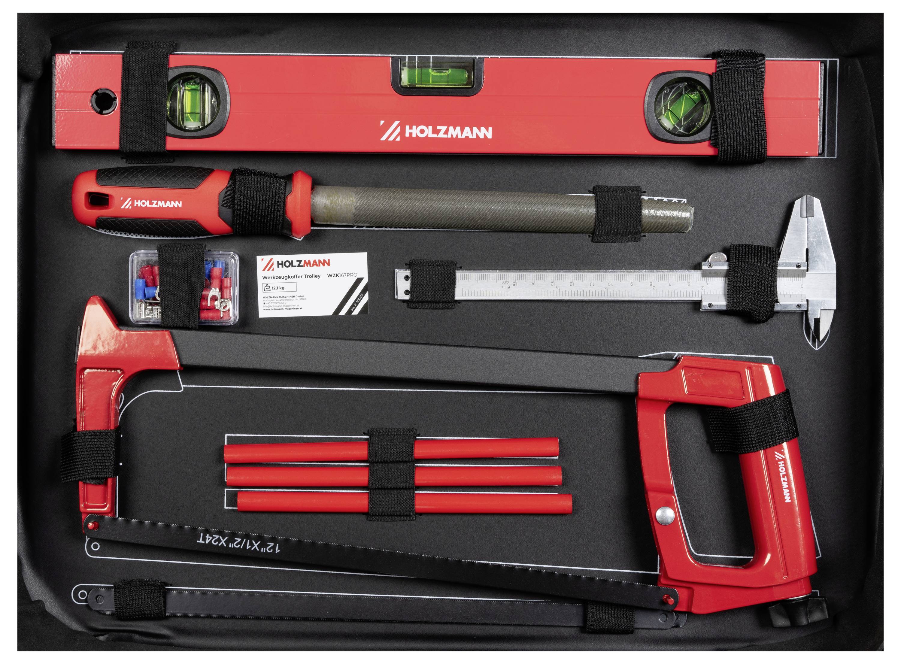 Zestaw narzędzi Holzmann z poziomicą, kluczem sześciokątnym, suwmiarką, piłą, ostrzami i wiertłami w czarnym etui, zorganizowany za pomocą elastycznych pasków.