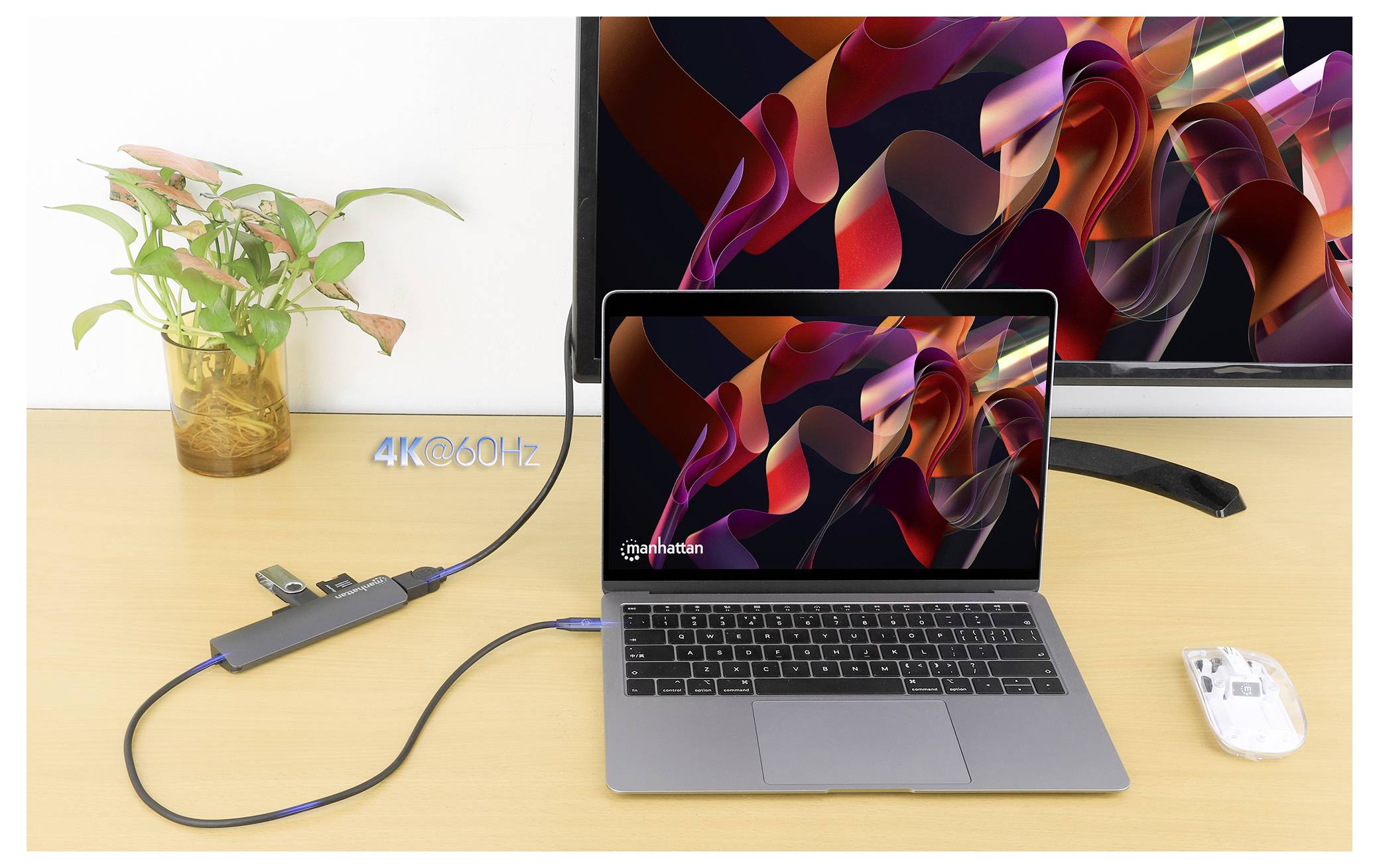 Laptop podłączony do stacji dokującej z wyjściem HDMI do monitora, prezentujący płynne rozdzielczość 4K przy 60Hz. Obok znajdują się roślina i mysz.