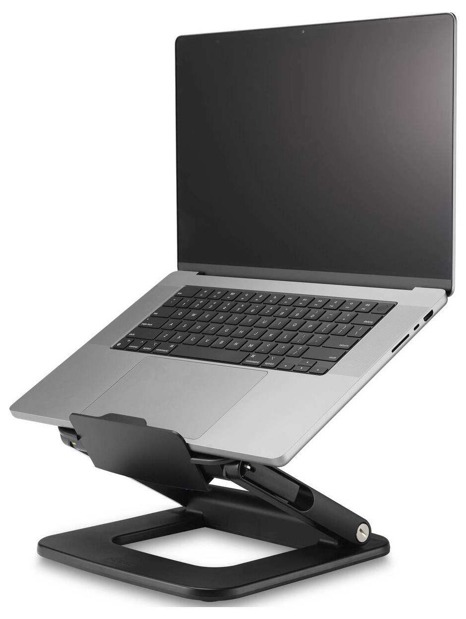 Srebrny laptop na czarnym, regulowanym stojaku, ustawiony pod lekkim kątem w górę, prezentujący klawiaturę i ekran.