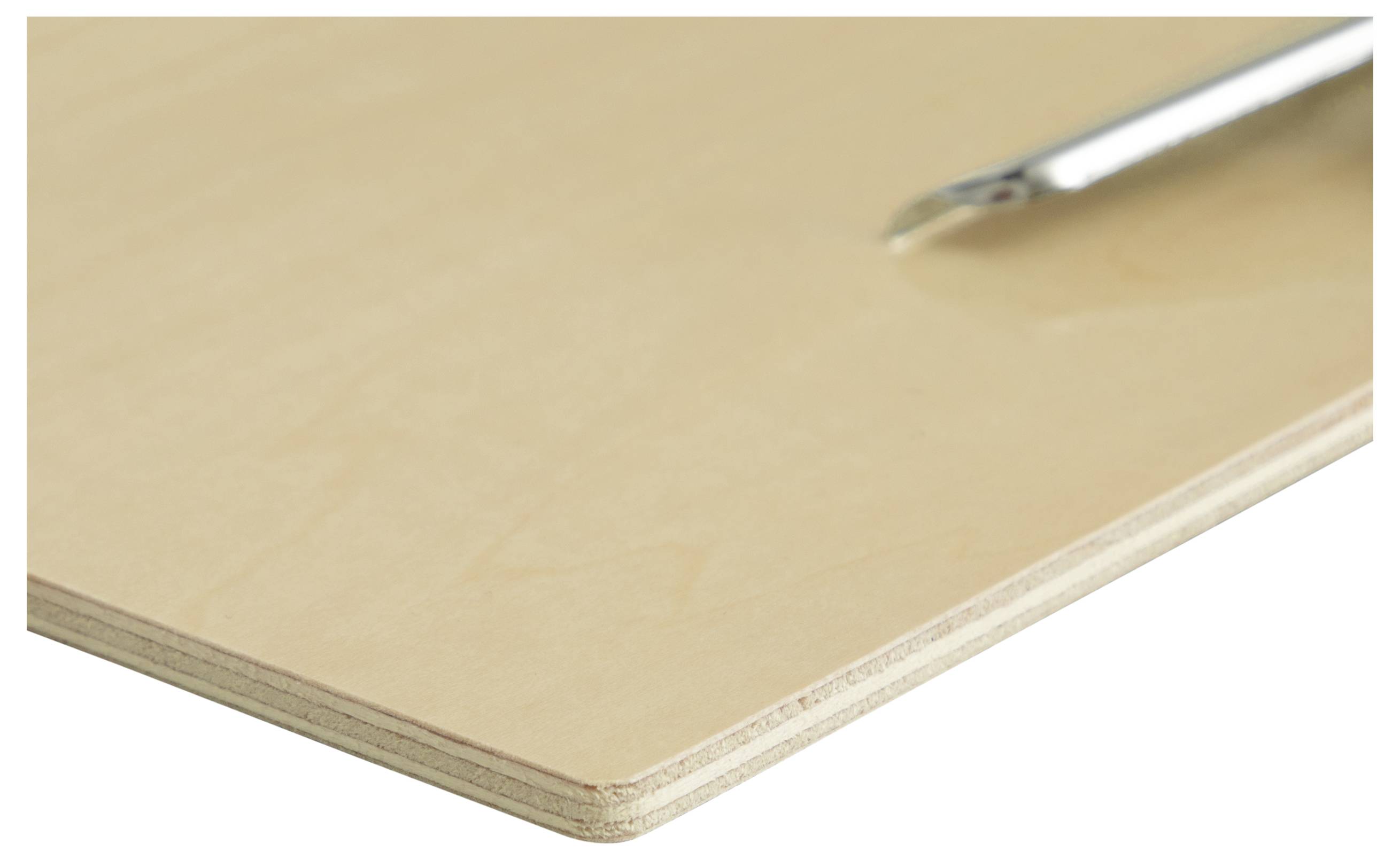 Skalpel spoczywa na czystej płycie sklejki, sugerując gotowość do precyzyjnego cięcia lub wykonywania rzemieślniczego zadania.