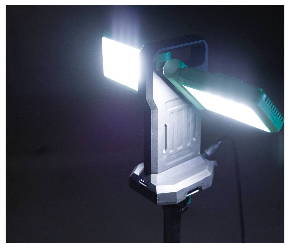 Przenośna lampa robocza LED z uchwytem i dwoma regulowanymi, jasnymi prostokątnymi światłami, oświetlająca ciemne tło.