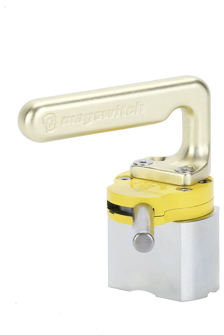Kompaktowy, metalowy przełącznik Magswitch z żółtą rączką, używany do magnetycznego mocowania obiektów w określonym miejscu.