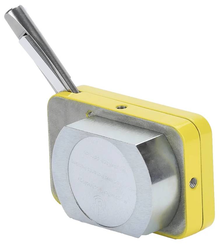 Żółty metalowy przyrząd z wystającą metalową rączką, prawdopodobnie narzędzie lub część maszyny. Szczegóły na okrągłej powierzchni nie są czytelne.