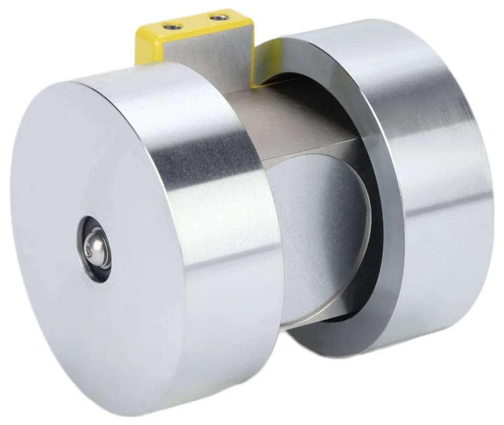 Zbliżenie metalowego urządzenia cylindrycznego z małym żółtym elementem na szczycie. Urządzenie posiada błyszczące powierzchnie i przemysłowy design.