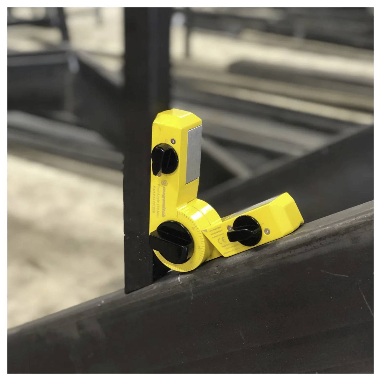 Żółte narzędzie do pomiaru kąta z magnesem jest przymocowane do stalowej belki, wyświetlające pomiar kąta dla precyzyjnej obróbki metalu.