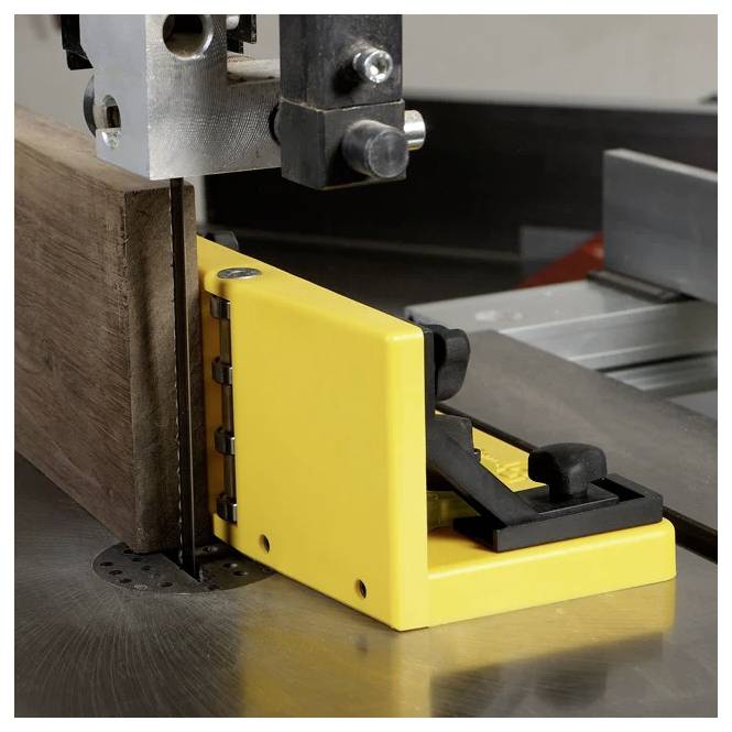 Piła taśmowa przecinająca kawałek drewna z żółtą prowadnicą bezpieczeństwa, zapewniająca precyzję i bezpieczeństwo.