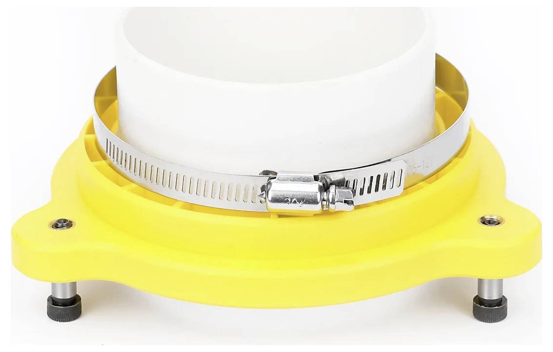 Żółta plastikowa struktura z metalowym zaciskiem zabezpiecza biały cylindryczny obiekt.