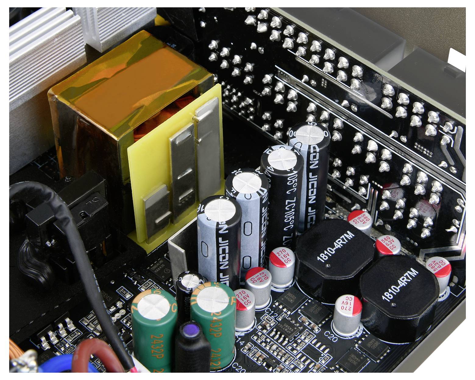 Widok wewnętrzny płyty głównej komputera przedstawiający kondensatory, rezystory i elementy elektroniczne. Kluczowe komponenty są starannie rozmieszczone.