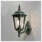 Zabytkowa lampa ścienna w kolorze zielonym, w stylu vintage, zamontowana na fakturowanej ścianie, wewnątrz której świeci się żarówka.