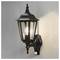 Czarny, stylizowany na vintage lampion zamocowany na ścianie, z żarzącą się żarówką wewnątrz, oświetlający otaczającą go teksturowaną powierzchnię.