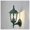 Zielona lampa naścienna z włączonym żarnikiem, rzucająca światło na teksturowaną ścianę; klasyczny design z ozdobnym zwieńczeniem na górze.