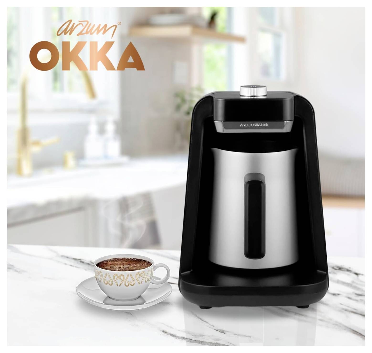 Ekspres do kawy z chromowanym dzbankiem obok filiżanki tureckiej kawy na marmurowym blacie. Logo 'Arzum OKKA' w lewym górnym rogu.