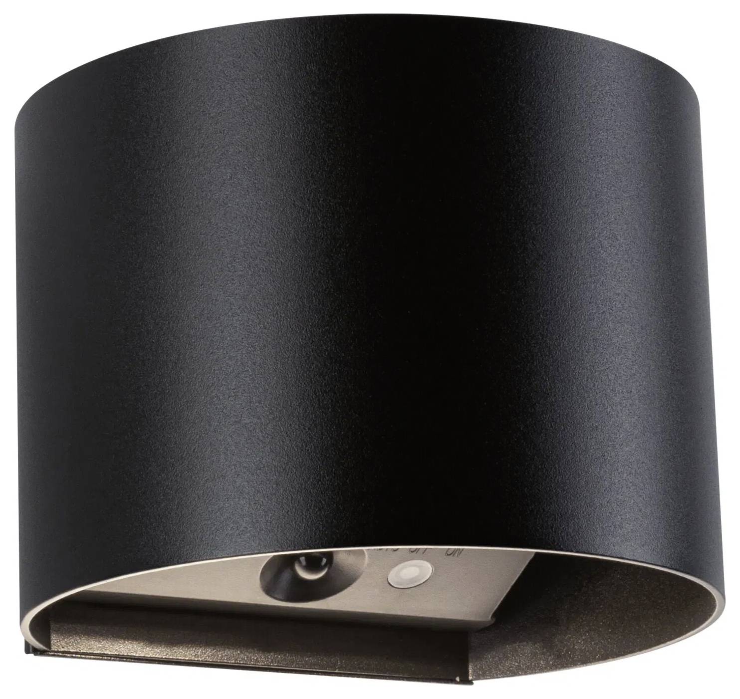 Czarna, cylindryczna lampa ścienna o minimalistycznym designie, z źródłem światła skierowanym w dół.