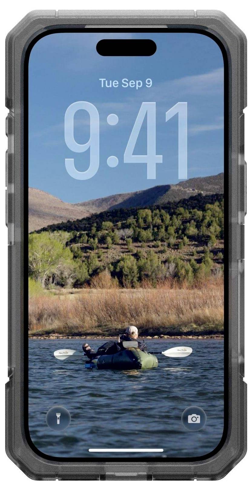 Na smartfonie wyświetla się ekran blokady z dużym zegarem pokazującym godzinę 9:41. Tapeta przedstawia osobę płynącą kajakiem po jeziorze, w tle widać góry.