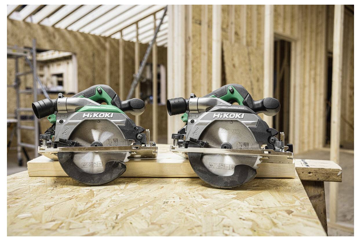 Piły tarczowe 'HiKOKI' na drewnianej powierzchni, w scenerii budowlanej z drewnianymi ramami i belkami w tle.