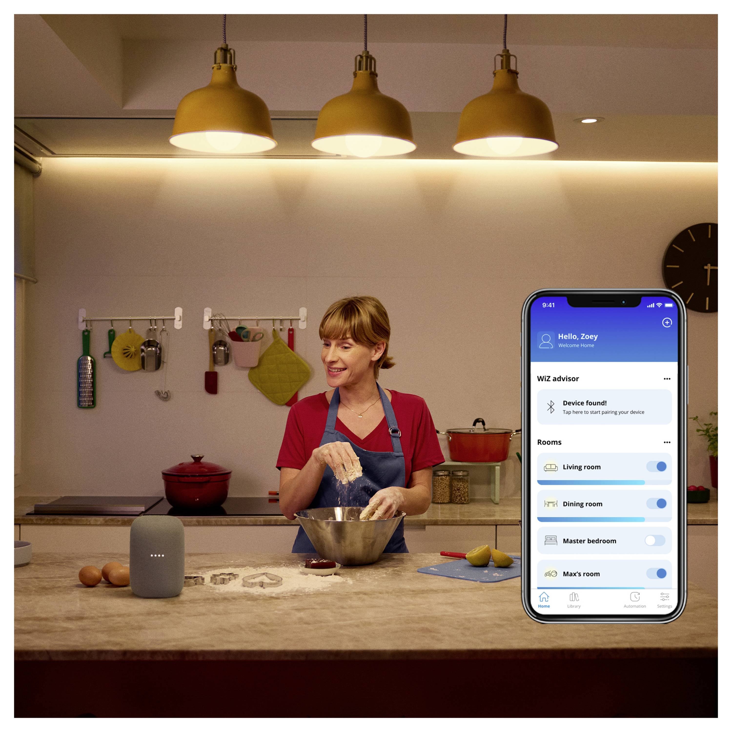 Kobieta gotuje w kuchni, jednocześnie korzystając z urządzenia inteligentnego domu. Interfejs aplikacji na smartfonie prezentuje sterowanie połączonymi pomieszczeniami.