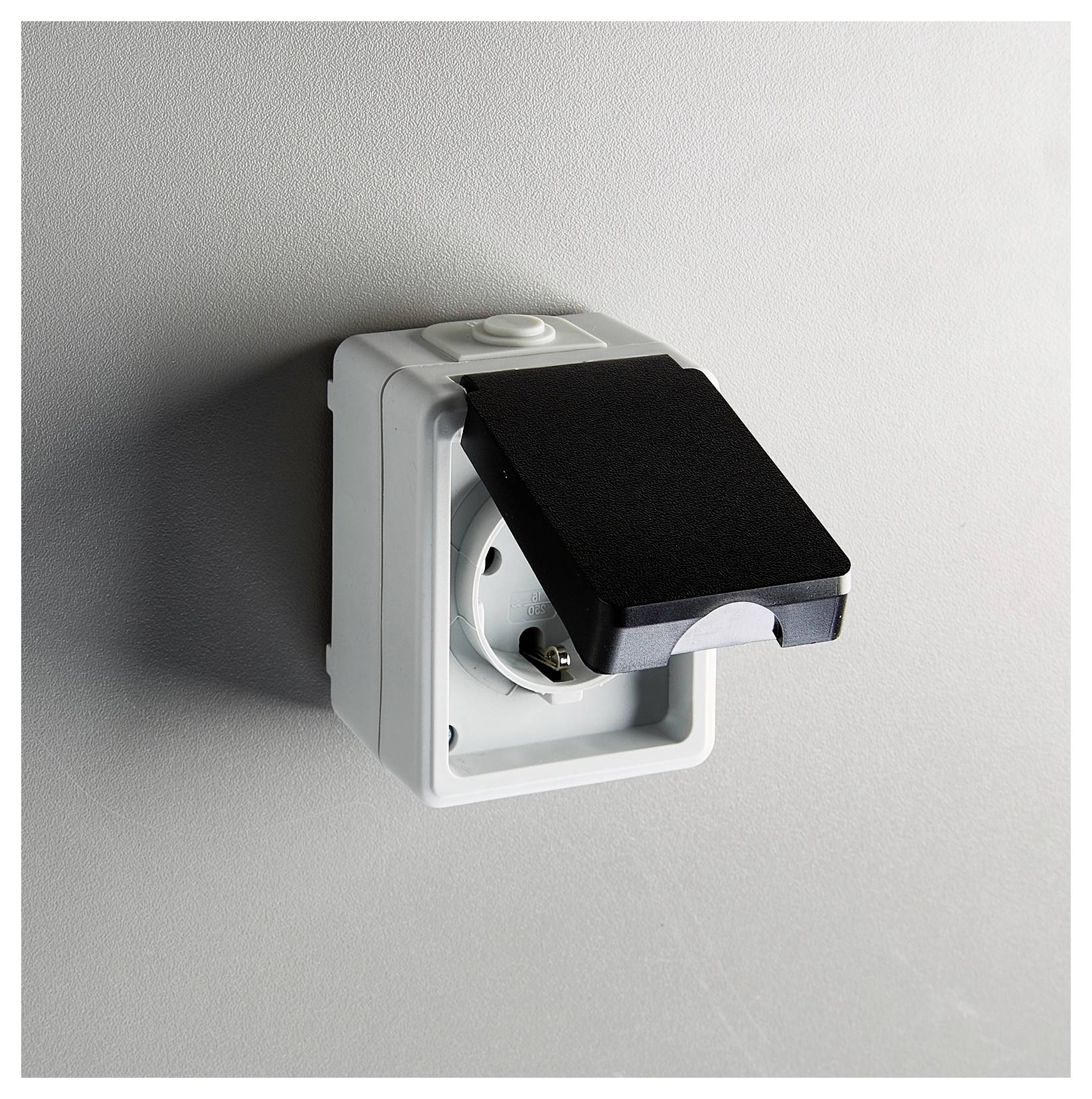 Naścienny kontakt elektryczny z zamkniętą osłoną ochronną, zaprojektowany z myślą o bezpieczeństwie i odporności na warunki atmosferyczne.