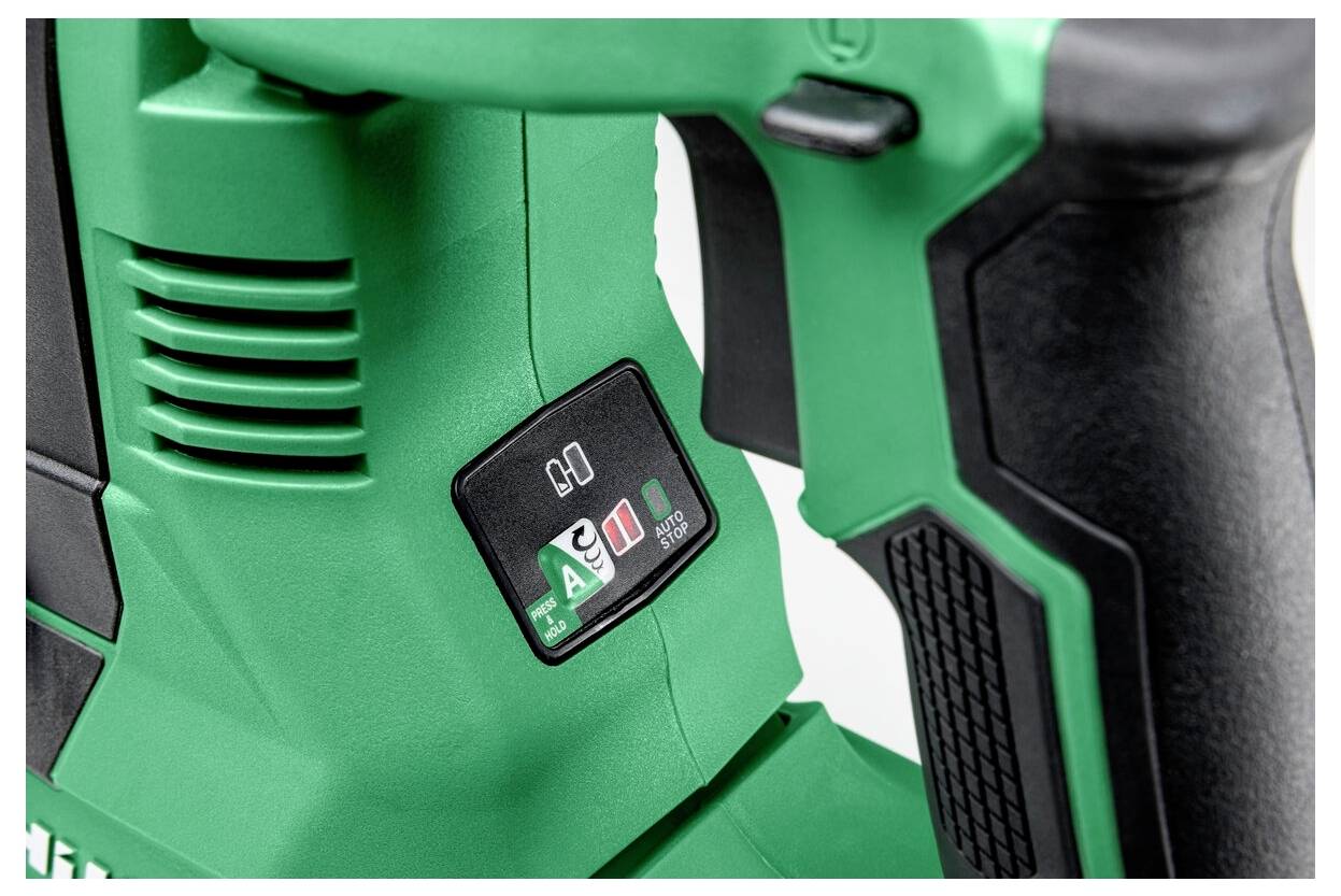 Zbliżenie na zielony uchwyt elektronarzędzia z czarnym uchwytem. Narzędzie posiada panel sterowania z ikonami i przyciskiem do regulacji ustawień aktywacji.