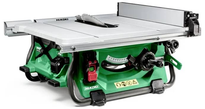 Zielono-szara piła stołowa z okrągłą tarczą tnącą, pokrętłami do regulacji oraz ostrzeżeniami dotyczącymi bezpieczeństwa. Jest przeznaczona do cięcia różnych materiałów.