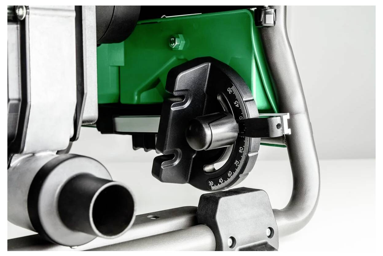 Zbliżenie przemysłowego komponentu maszyny z ponumerowanym pokrętłem i solidną metalową ramą na zielonym tle.