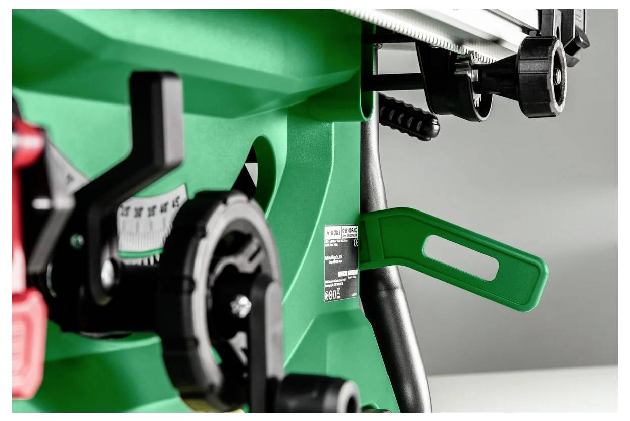 Zbliżenie zielonej maszyny przemysłowej z różnymi zębatkami i dźwigniami, ze szczególnym uwypukleniem zielonej dźwigni i miernika pomiarowego.