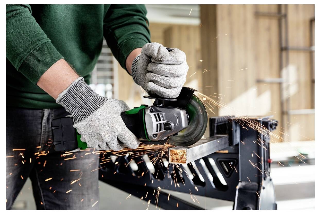 Osoba w rękawicach używa szlifierki kątowej na fragmencie metalu, przy czym lecą iskry.