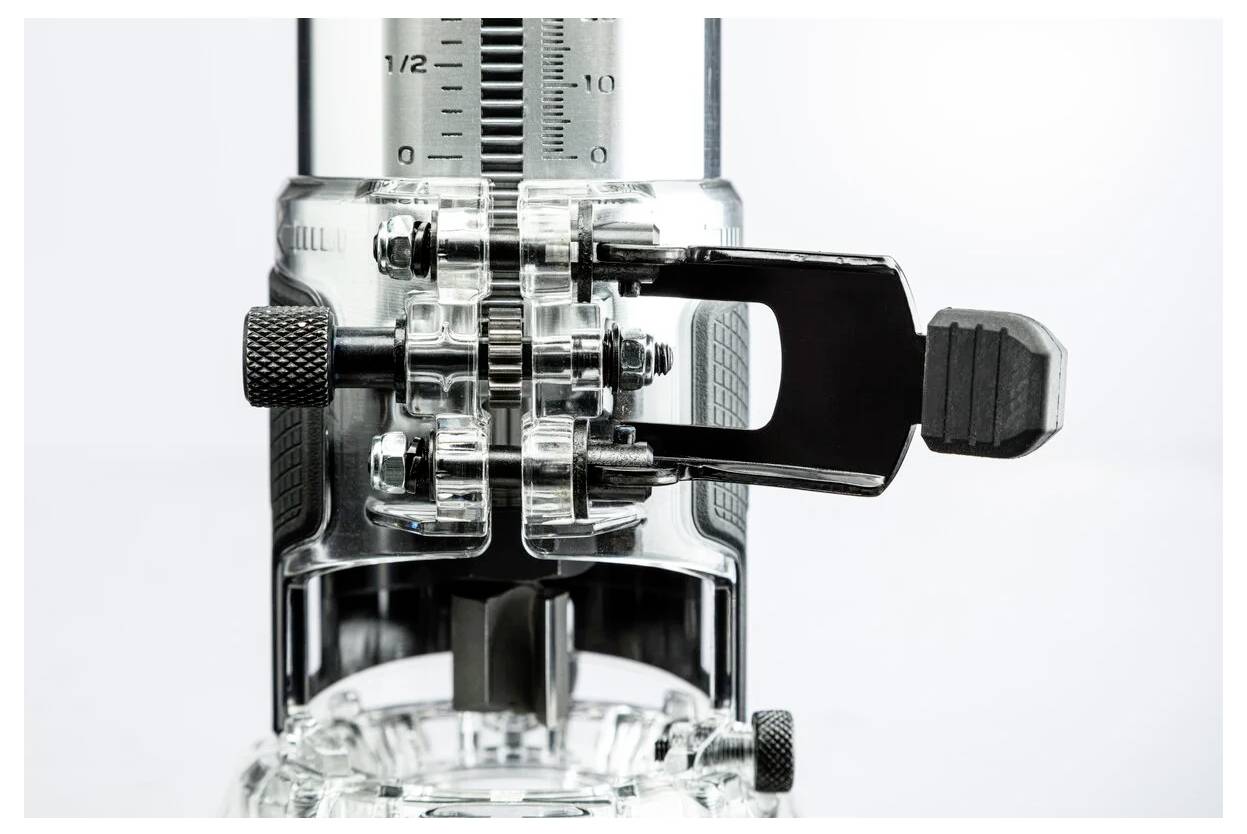 Zbliżenie metalowo-plastikowego narzędzia mechanicznego z linijką i pokrętłami regulacyjnymi, używanego do precyzyjnych pomiarów lub regulacji.