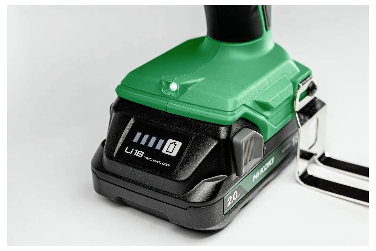 Zbliżenie akumulatora zielonego i czarnego elektronarzędzia bezprzewodowego, przedstawiające wskaźniki poziomu naładowania oraz etykietę z napisem „technologia Li 18".
