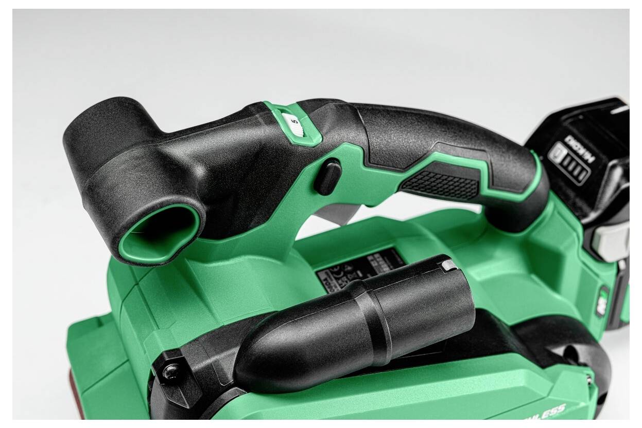 Zielone i czarne ręczne elektronarzędzie, wyposażone w teksturowaną rękojeść i akumulator, przeznaczone do zadań związanych z przycinaniem lub cięciem.