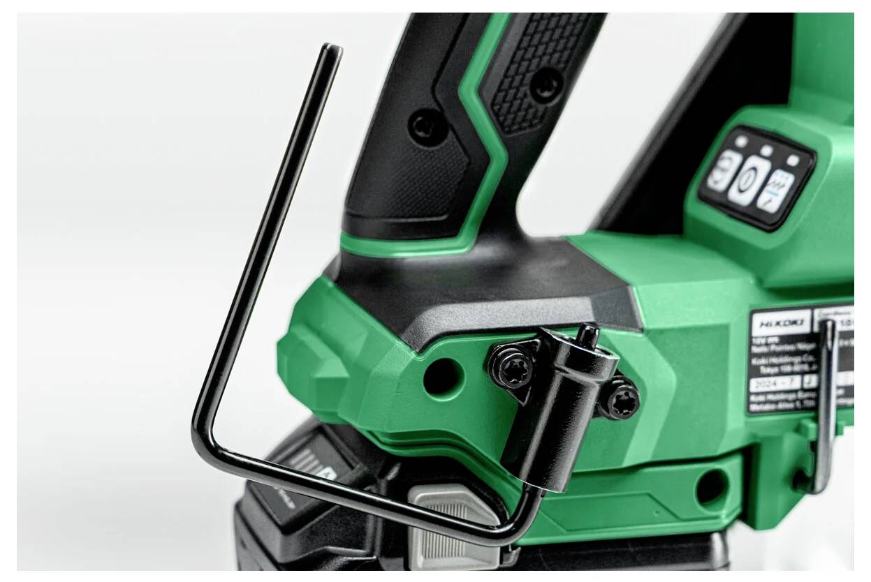 Zielono-czarne narzędzie elektryczne z ergonomicznym uchwytem i przyciskami sterującymi, obok którego znajduje się L-kształtny klucz sześciokątny przymocowany do jego boku.