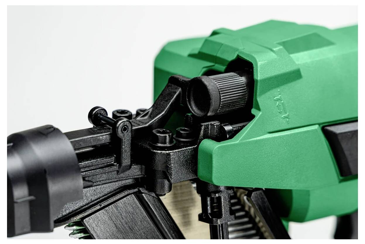 Zbliżenie zielonego narzędzia elektrycznego ze szczególnym uwzględnieniem pokrętła regulacyjnego i spustu, wskazujące na przygotowanie do pracy.