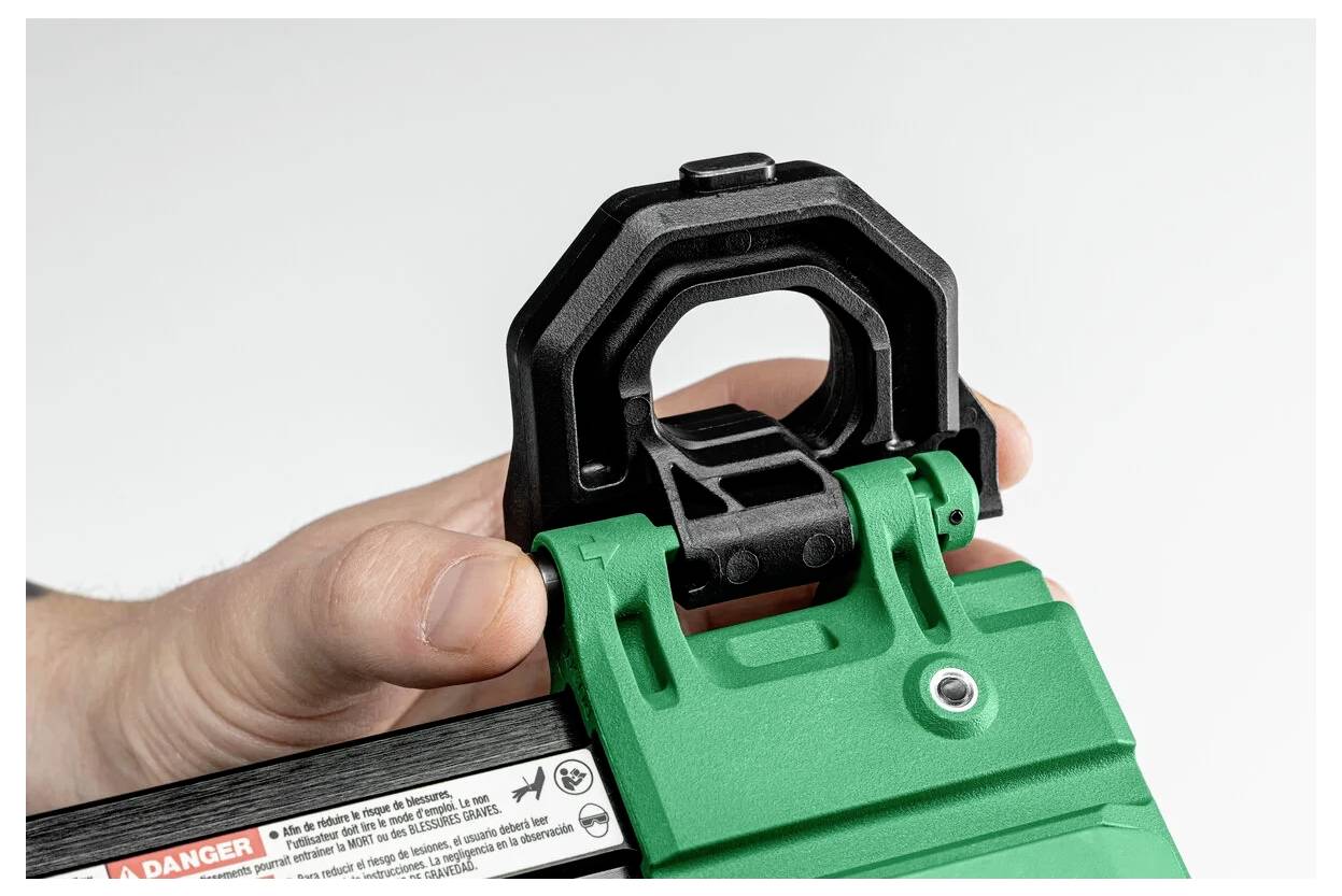 Ręka trzymająca zielone urządzenie z czarną regulowaną zatrzaśniętą blokadą, wskazującą mechanizm do zamykania lub zabezpieczania obiektu.