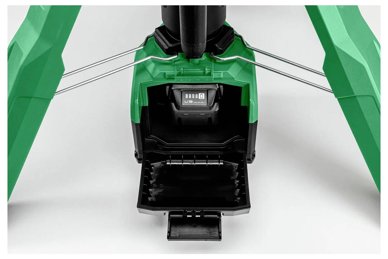 Zbliżenie komory baterii dmuchawy w kolorach zielonym i czarnym, przedstawiające otwartą klapkę z pustym gniazdem, w które wkłada się baterię.