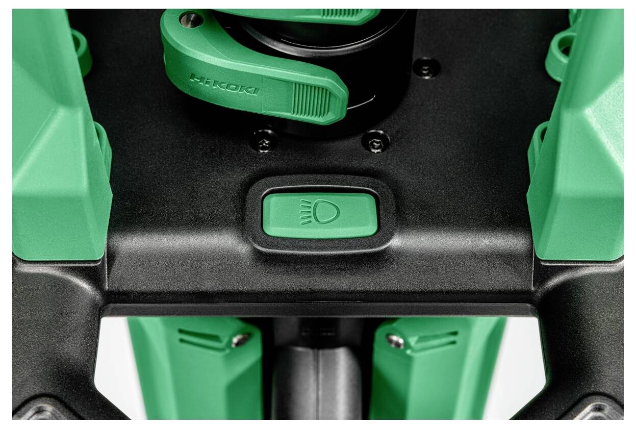 Zbliżenie zielonego panelu sterowania z przyciskiem oznaczonym ikoną żarówki, prawdopodobnie wskazujący funkcję włączania zasilania lub światła.