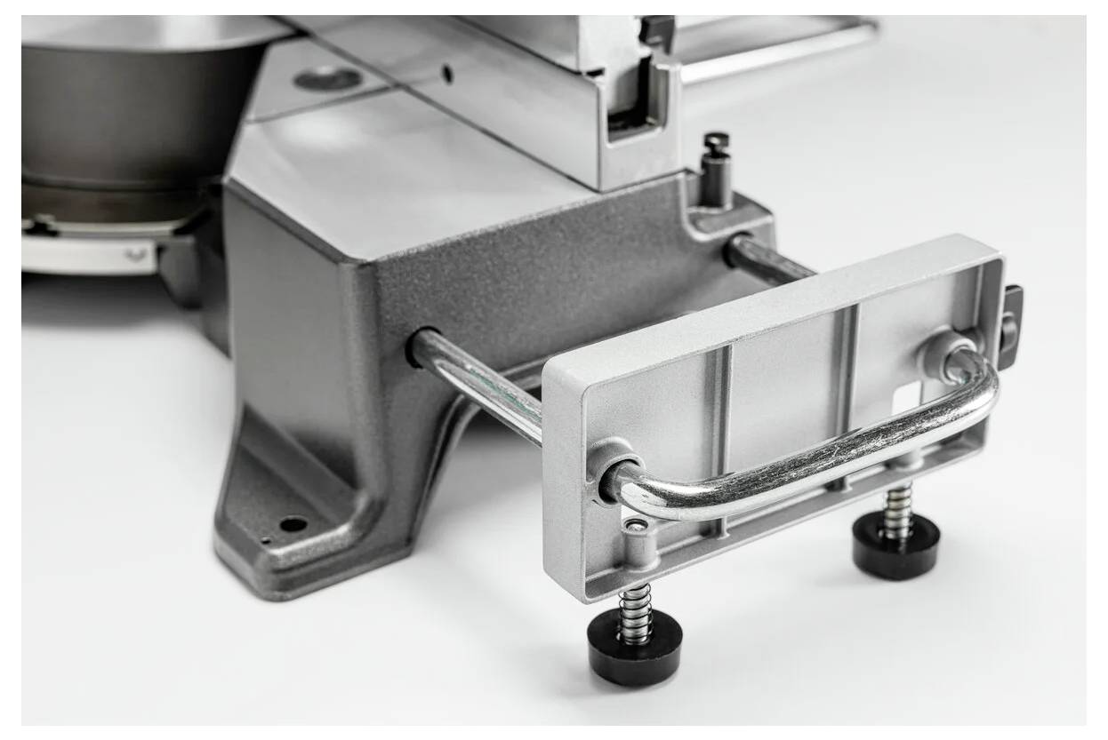 Obraz przedstawia podstawę metalowego urządzenia z regulowanymi stopkami i prostokątną belką stabilizacyjną, zaprojektowaną dla zapewnienia stabilności i wypoziomowania.