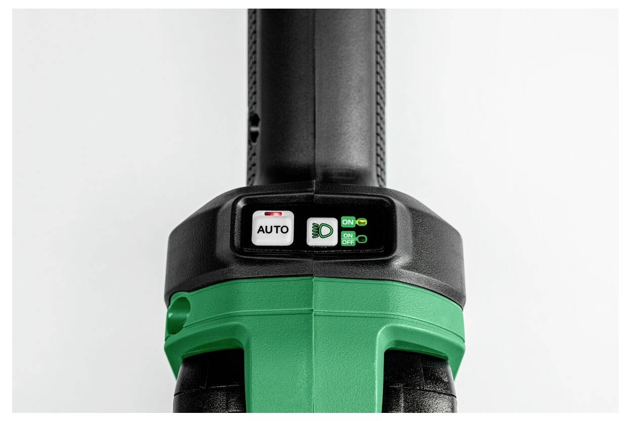 Zbliżenie zielonego i czarnego narzędzia elektrycznego z przyciskiem oznaczonym AUTO i przełącznikami. Urządzenie wydaje się być w stanie nieaktywnym.