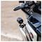 Zbliżenie kierownicy motocykla z małą czarną kamerą zamontowaną z przodu. W tle rozmazana droga.