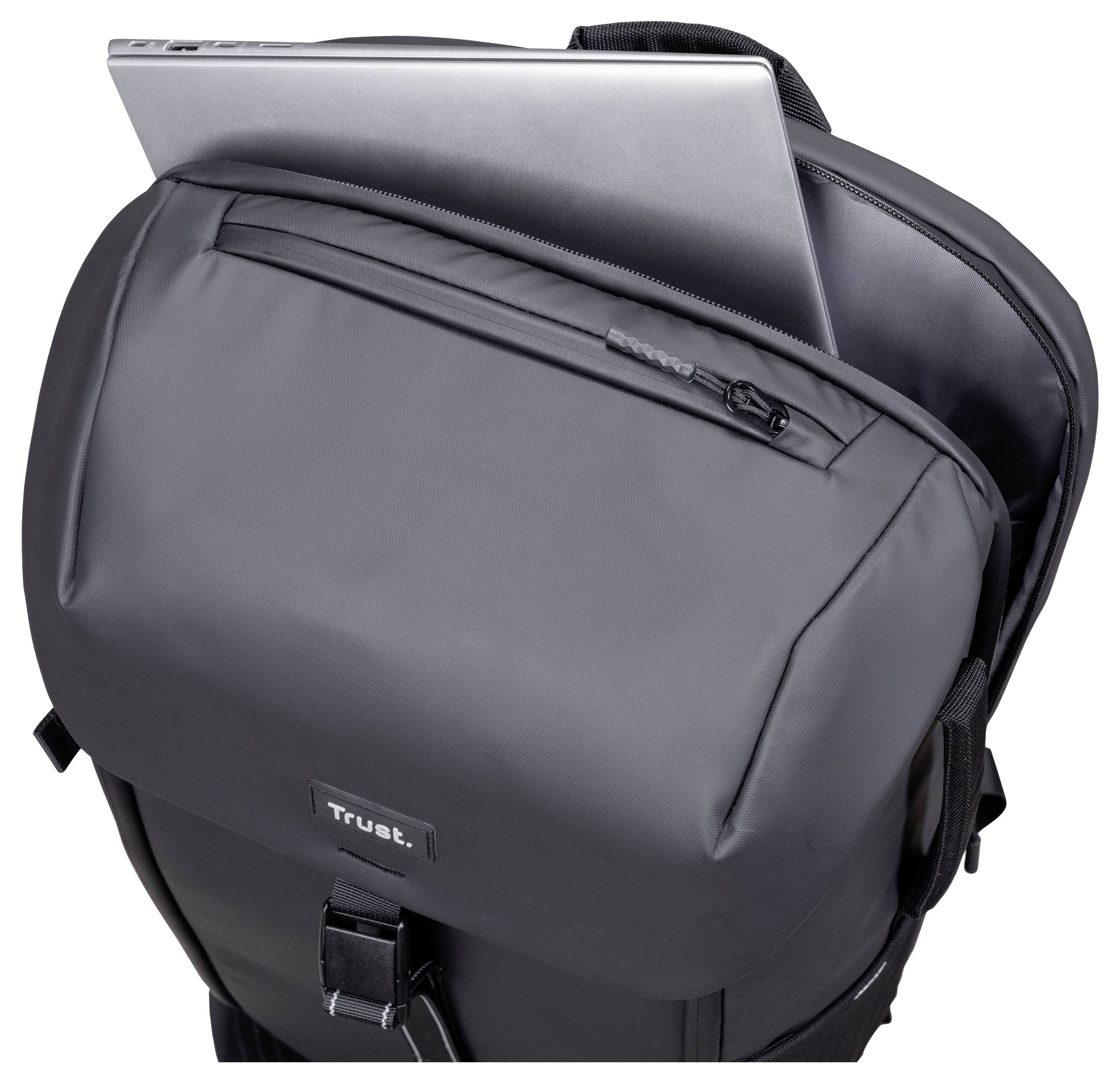 Szary plecak częściowo otwarty, z widocznym laptopem w górnej części komory. Na przedniej kieszeni znajduje się etykieta marki „Trust".