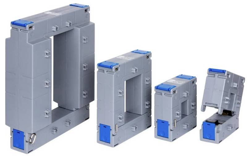 Cztery prostokątne, szare elementy transformatorów elektrycznych z niebieskimi akcentami są ułożone w rzędzie, o różnej wielkości - od dużych do małych.