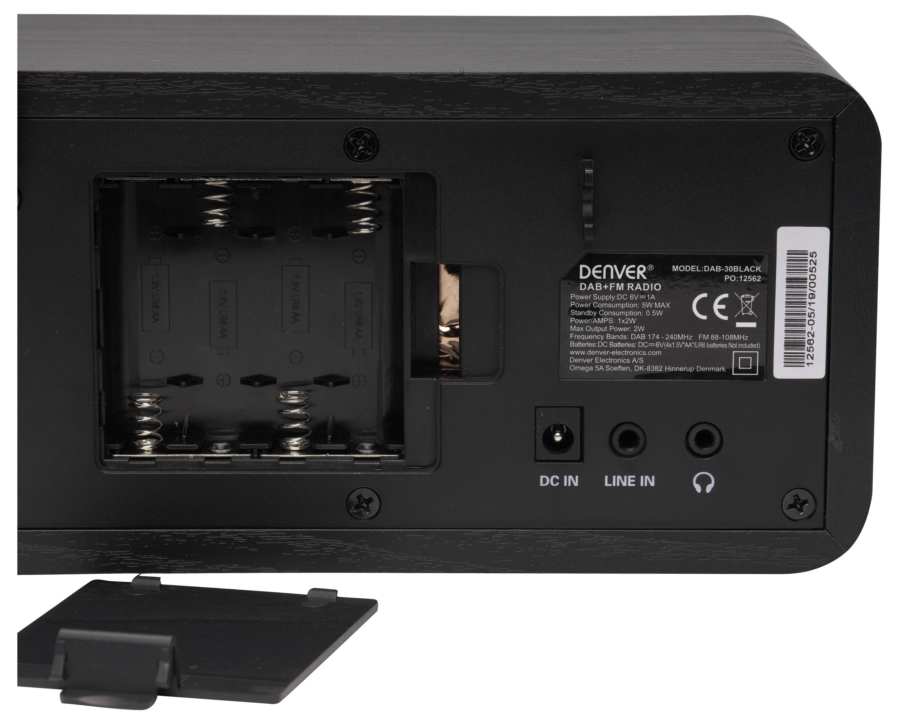 Widok z tyłu czarnego radia DAB+/FM z odkrytą komorą baterii, gniazdem zasilania oraz portami wejścia i wyjścia audio. Pokrywa jest zdjęta.