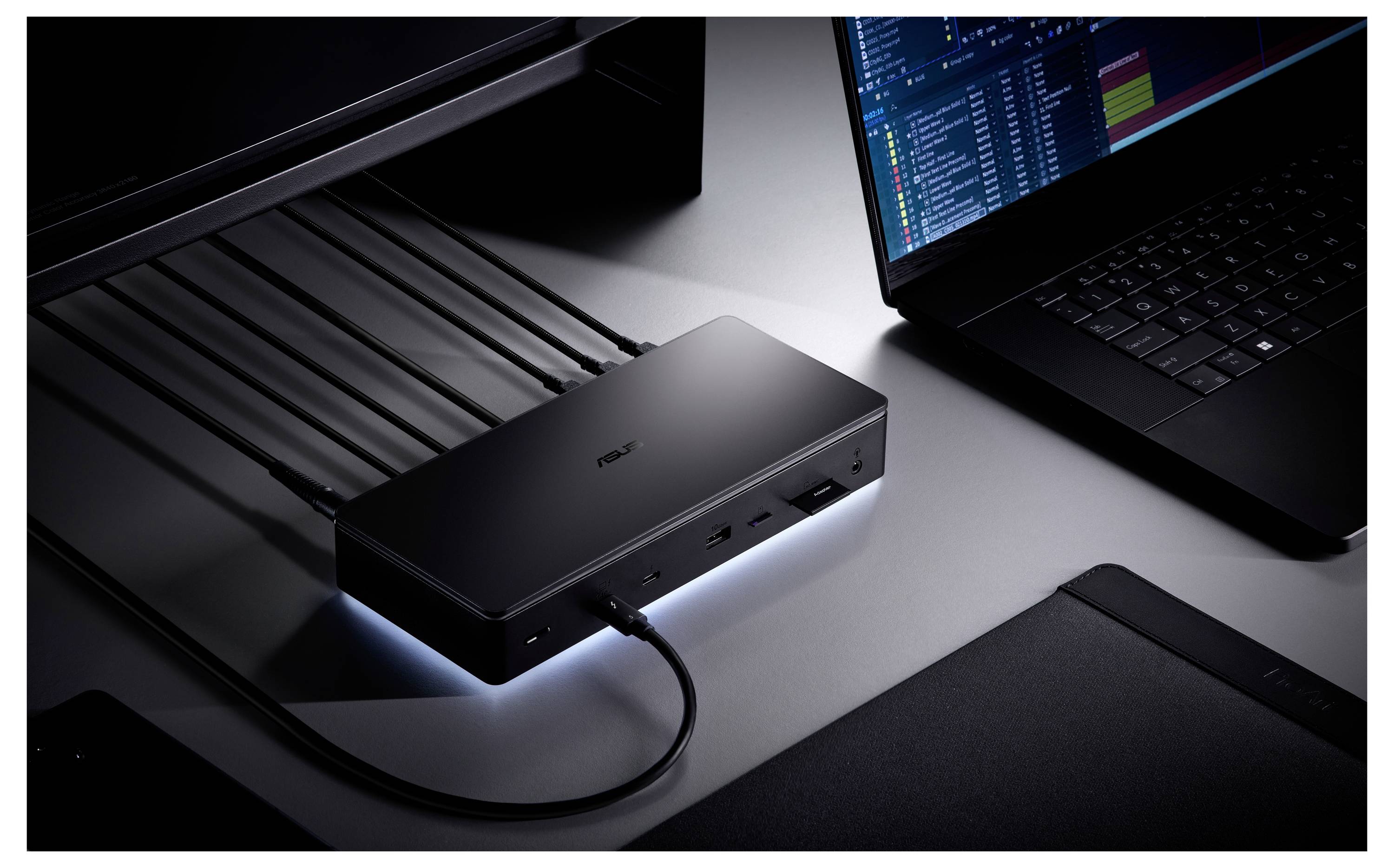 Laptop podłączony do stacji dokującej z wieloma podpiętymi kablami, rozszerzający opcje łączności.