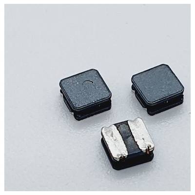 Trzy małe elementy elektroniczne na jasnej powierzchni, jeden z widocznymi elementami metalowymi, prawdopodobnie do integracji lub naprawy obwodu.