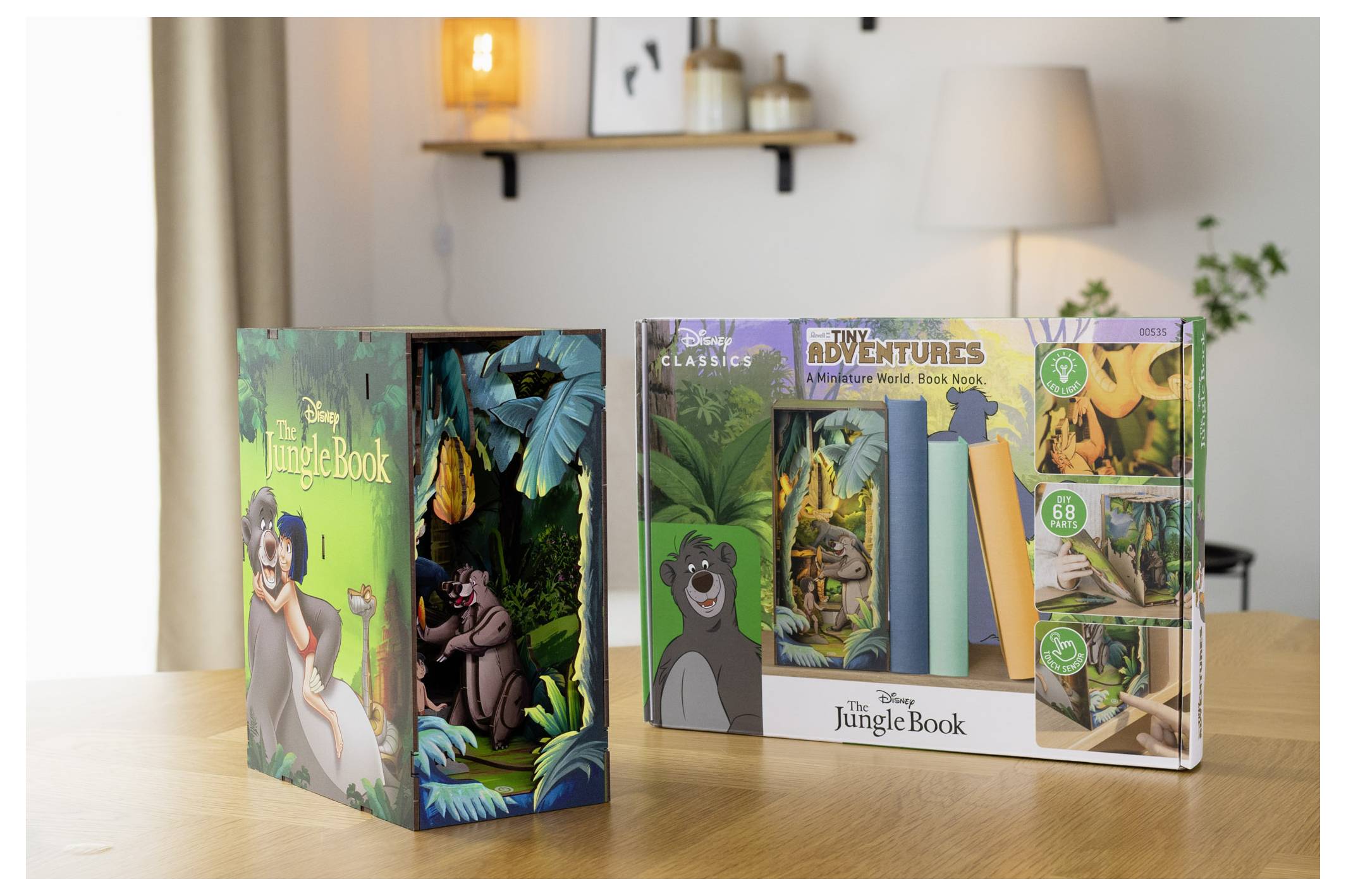 Trzywymiarowy model książki i papieru z serii Disney'a 'Księga dżungli' z postaciami takimi jak Baloo na okładce, prezentowany na drewnianym stole.