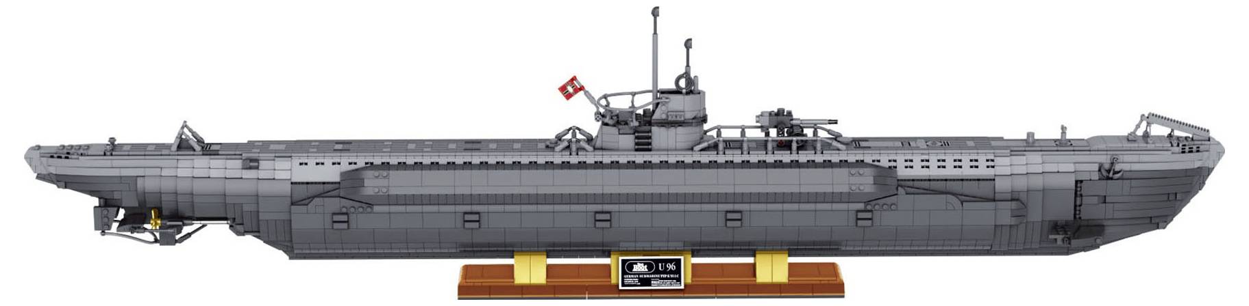 Model miniaturowej, szczegółowej, szarej łodzi podwodnej na podstawce wystawowej, z małą flagą na szczycie i precyzyjnie odwzorowanymi elementami wzdłuż kadłuba.