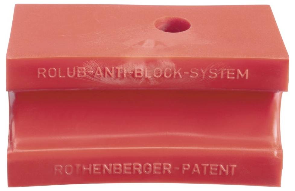 Czerwony plastikowy blok oznaczony napisami 'Rolub Anti-Block-System' i 'Rothenberger-Patent' z otworem na górze. Stosowany w hydraulice lub budownictwie.