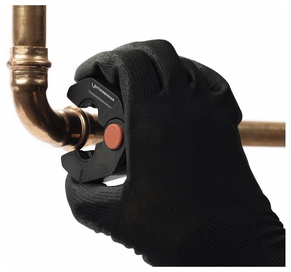 Dłoń w czarnej rękawicy używa obcinaka do rur, aby przeciąć miedzianą rurę, prezentując narzędzie hydrauliczne w akcji.