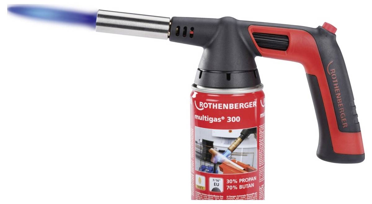 Czerwono-czarny ręczny palnik z niebieskim płomieniem, oznaczony etykietą 'ROTHENBERGER multigas 300', zapala mieszankę gazu propan-butan.