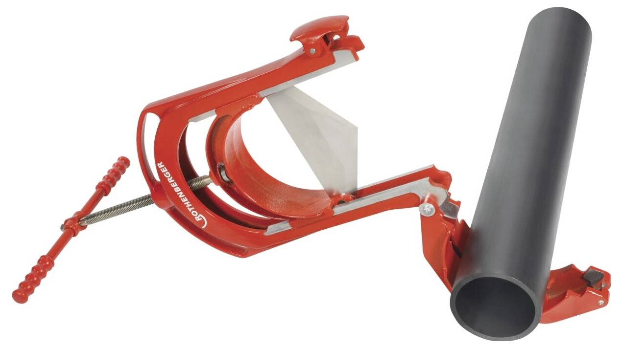 Czerwony obcinacz do rur trzymający czarną rurę, prezentujący ostrze ustawione do cięcia.