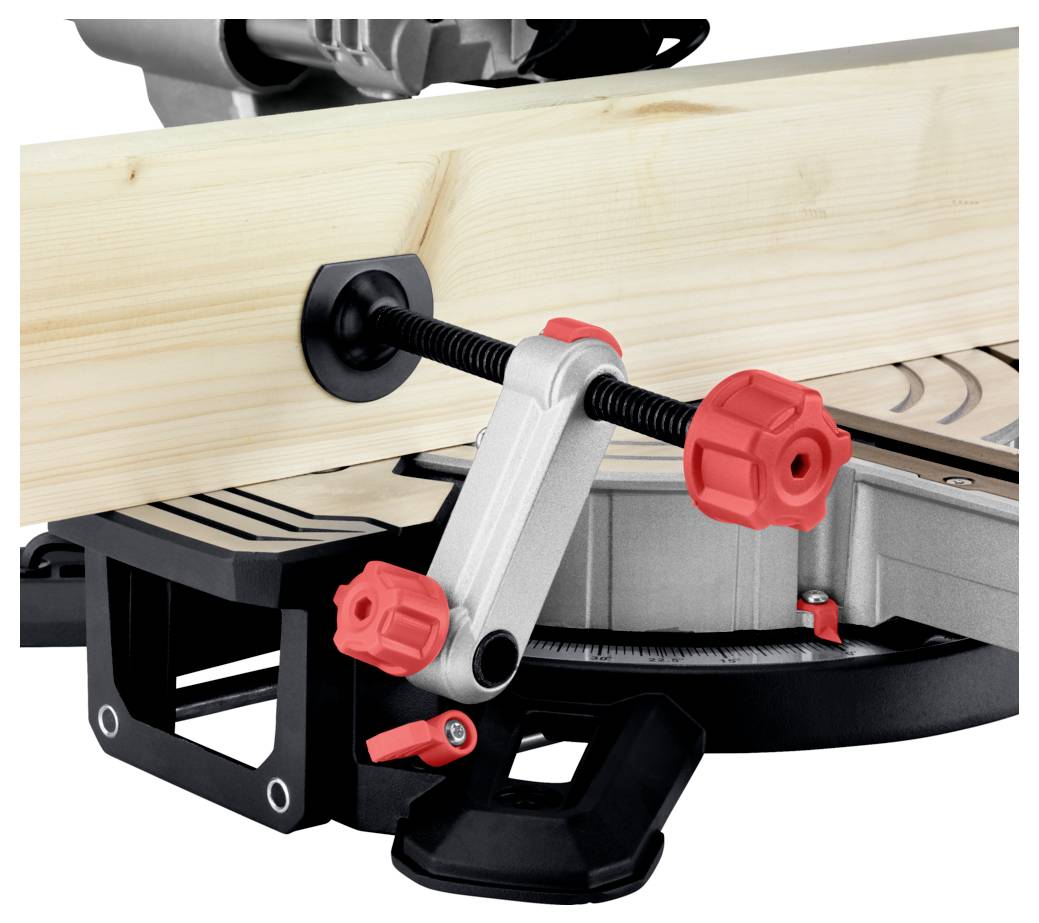 Kawałek drewna zabezpieczony czerwonym zaciskiem w pile ukośnej, wskazujący na przygotowanie do cięcia.